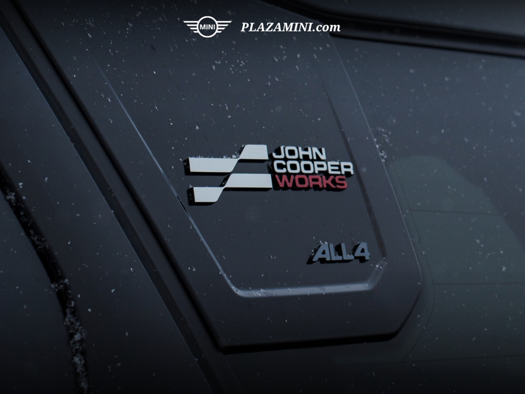 Logo John Cooper Works dan emblem ALL4 pada MINI Countryman, menandakan sistem penggerak empat roda pintar yang memberikan traksi dan stabilitas maksimal di segala kondisi jalan.
