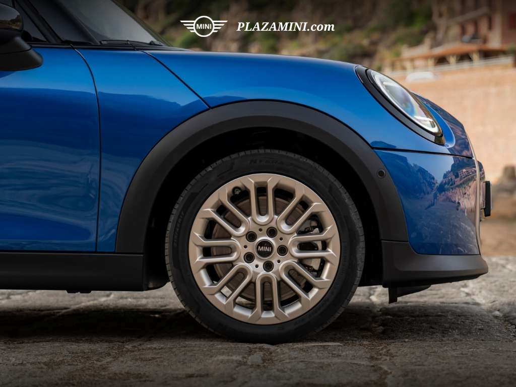 Tampilan close-up velg MINI Cooper S 2025 berdesain sporty two-tone dengan fender hitam kontras di bodi biru.
