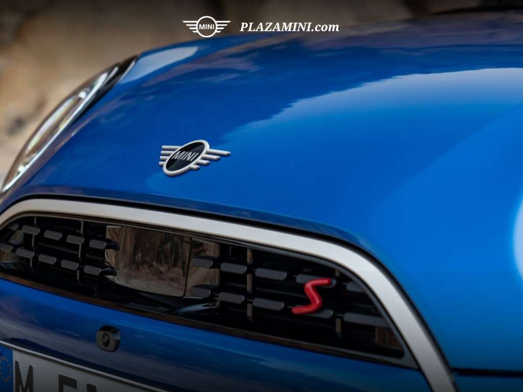Detail close-up grille depan MINI Cooper S 2025 dengan logo MINI dan emblem huruf S merah yang menegaskan kesan sporty.